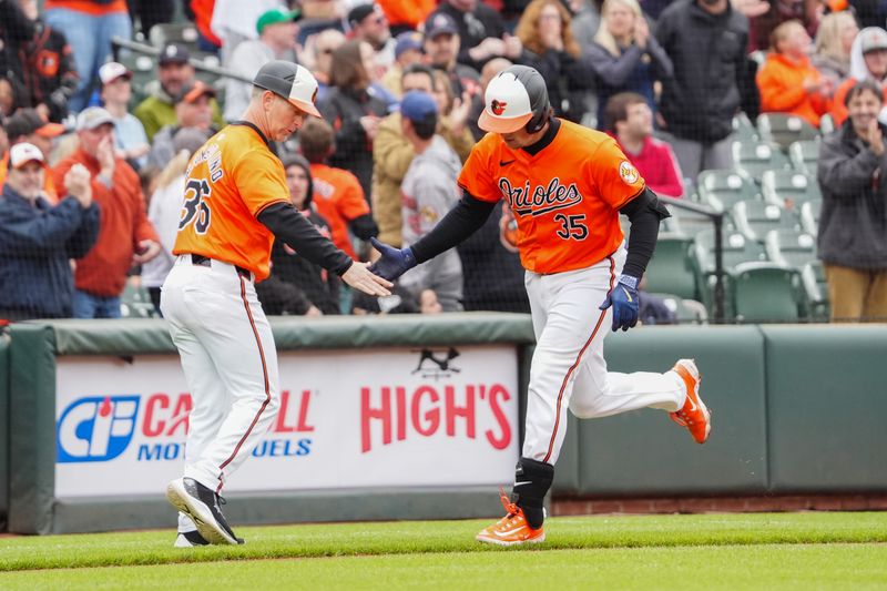 Apr 27, 2024; Baltimore, Maryland, USA; Baltimore Orioles third base coach Tony Mansolino (36) congratulates designated hitter Adley Rutschman (35) for hitting home run during the fifth inning at Oriole Park at Camden Yards. Mandatory Credit: Gregory Fisher-USA TODAY Sports