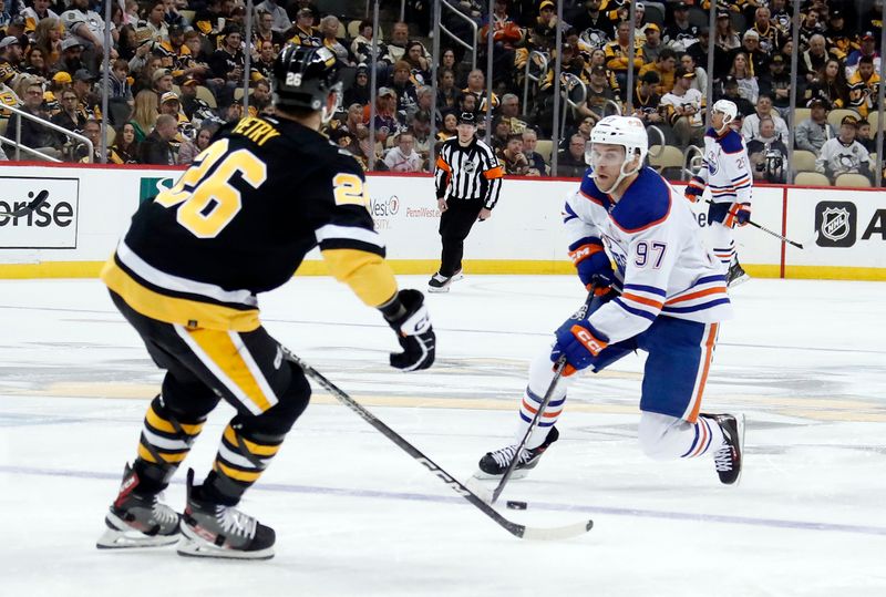 Feb 23, 2023; Pittsburgh, Pennsylvania, USA; Edmonton Oilers center Connor McDavid (97) skates into the offensive zone with the puck against Pittsburgh Penguins defenseman Jeff Petry (26) during the third period at PPG Paints Arena. Edmonton won 7-2. Mandatory Credit: Charles LeClaire-USA TODAY Sports