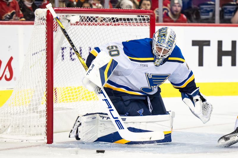 Dec 5, 2024; Calgary, Alberta, CAN; St. Louis Blues goaltender Jordan Binnington (50) keeps his eye on the puck during the second period against the Calgary Flames at Scotiabank Saddledome. Mandatory Credit: Brett Holmes-Imagn Images