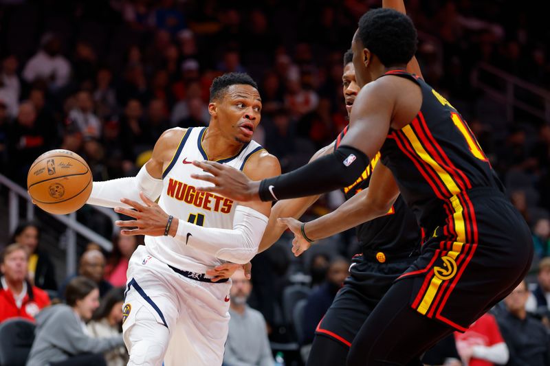 ATLANTA, GEORGIA - DECEMBER 08: Russell Westbrook #4 of the Denver Nuggets battles De'Andre Hunter #12 and Onyeka Okongwu #17 of the Atlanta Hawks during the first quarter at State Farm Arena on December 8, 2024 in Atlanta, Georgia. NOTE TO USER: User expressly acknowledges and agrees that, by downloading and or using this photograph, User is consenting to the terms and conditions of the Getty Images License Agreement. (Photo by Todd Kirkland/Getty Images)