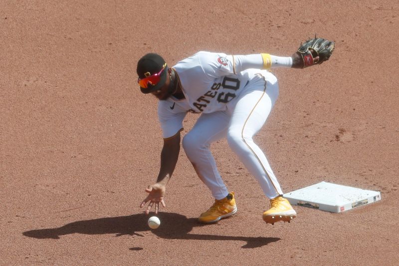 Sep 6, 2023; Pittsburgh, Pennsylvania, USA;  Pittsburgh Pirates shortstop Liover Peguero (60) bare hands a ball that went for a single by Milwaukee Brewers catcher William Contreras (not pictured) during the fifth inning at PNC Park. Pittsburgh won 5-4. Mandatory Credit: Charles LeClaire-USA TODAY Sports