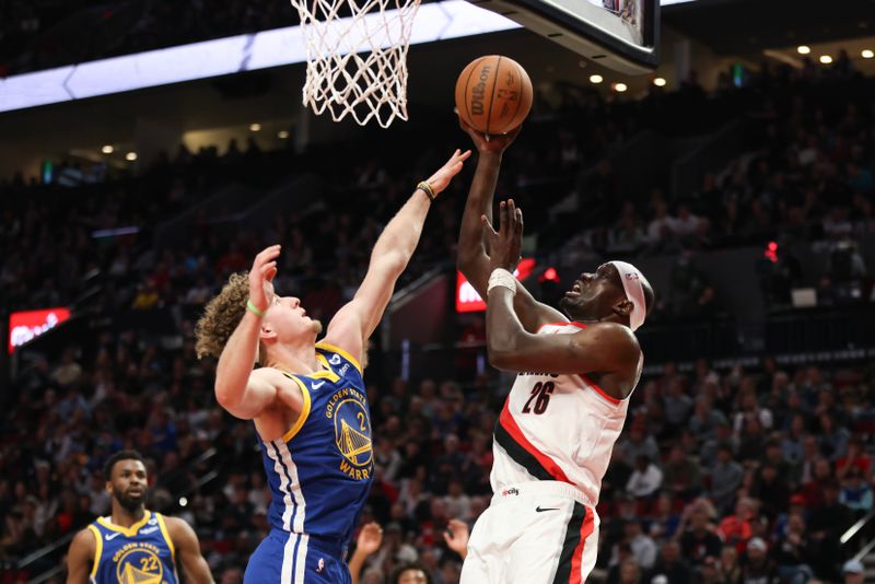 PORTLAND, OREGON - APRIL 11: Duop Reath #26 of the Portland Trail Blazers drives to the basket as Brandin Podziemski #2 of the Golden State Warriors defends during the fourth quarter at Moda Center on April 11, 2024 in Portland, Oregon. NOTE TO USER: User expressly acknowledges and agrees that, by downloading and or using this photograph, User is consenting to the terms and conditions of the Getty Images License Agreement.? (Photo by Amanda Loman/Getty Images)