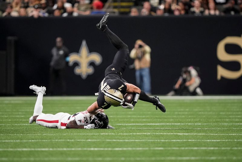 Atlanta Falcons cornerback Clark Phillips III (22) upends New Orleans Saints tight end Taysom Hill (7) during the first half of an NFL football game, Sunday, Nov. 10, 2024, in New Orleans. (AP Photo/Gerald Herbert)