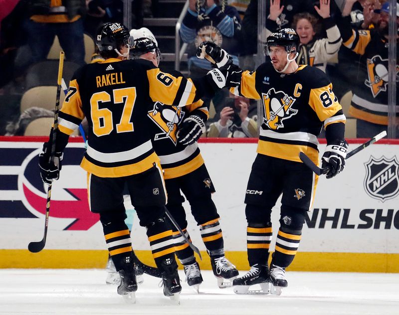 Jan 15, 2024; Pittsburgh, Pennsylvania, USA; Pittsburgh Penguins center Sidney Crosby (87) celebrates his goal with right wing Rickard Rakell (67) and left wing Jake Guentzel (middle)against the Seattle Kraken during the second period at PPG Paints Arena. Mandatory Credit: Charles LeClaire-USA TODAY Sports