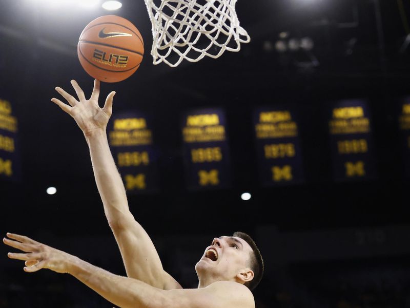 Feb 27, 2025; Ann Arbor, Michigan, USA;  Michigan Wolverines center Vladislav Goldin (50) shoots the ball against Rutgers Scarlet Knights guard Tyson Acuff (5) in the first half at Crisler Center. Mandatory Credit: Rick Osentoski-Imagn Images