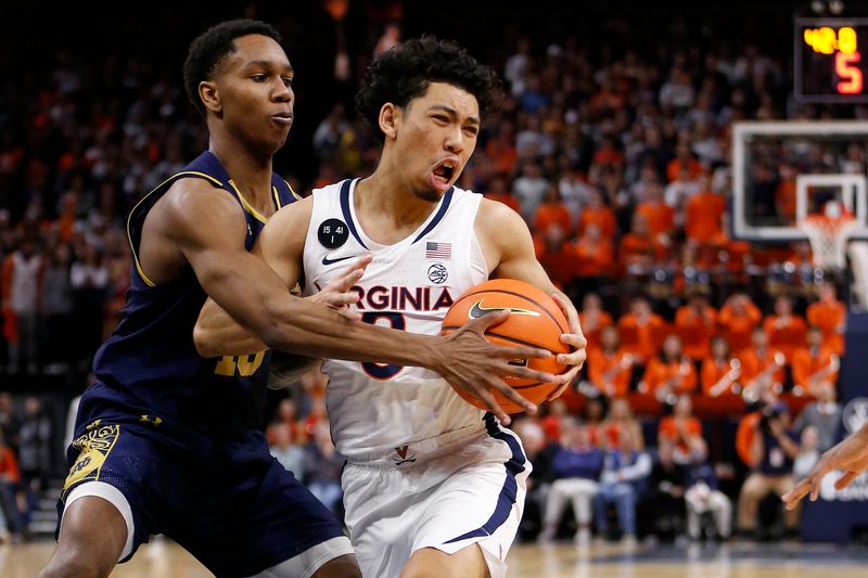 Feb 18, 2023; Charlottesville, Virginia, USA; Virginia Cavaliers guard Kihei Clark (0) controls the ball as Notre Dame Fighting Irish guard Marcus Hammond (10) defends during the second half at John Paul Jones Arena. Mandatory Credit: Amber Searls-USA TODAY Sports