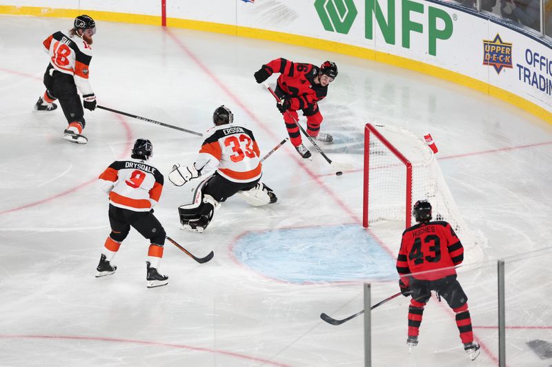 Feb 17, 2024; East Rutherford, New Jersey, USA; New Jersey Devils center Jack Hughes (86) plays the puck behind Philadelphia Flyers goaltender Samuel Ersson (33) in a Stadium Series ice hockey game at MetLife Stadium. Mandatory Credit: Vincent Carchietta-USA TODAY Sports