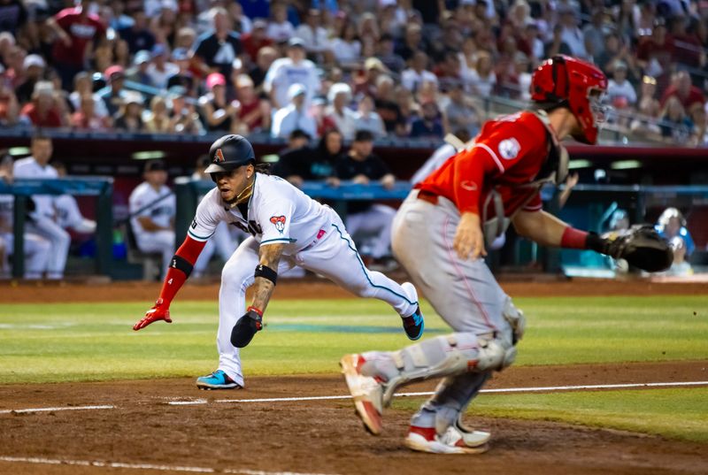 Aug 27, 2023; Phoenix, Arizona, USA; Arizona Diamondbacks base runner Ketel Marte dives into home to score in the eighth inning against the Cincinnati Reds at Chase Field. Mandatory Credit: Mark J. Rebilas-USA TODAY Sports