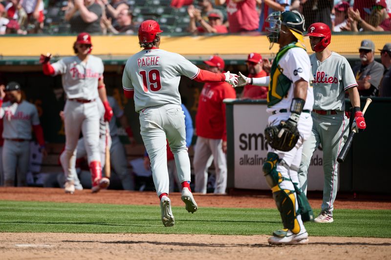 Jun 17, 2023; Oakland, California, USA; Philadelphia Phillies outfielder Cristian Pache (19) shakes hands with infielder Trea Turner (7) after scoring a run against the Oakland Athletics during the twelfth inning at Oakland-Alameda County Coliseum. Mandatory Credit: Robert Edwards-USA TODAY Sports