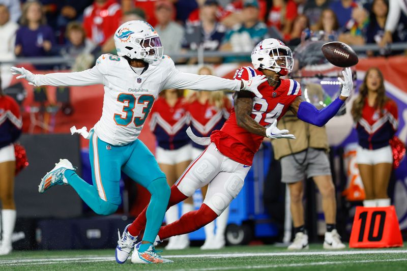 New England Patriots wide receiver Kendrick Bourne (84) nearly makes a reception while defended by Miami Dolphins cornerback Eli Apple (33) during the first half of an NFL football game on Sunday, Sept. 17, 2023, in Foxborough, Mass. (AP Photo/Greg M. Cooper)