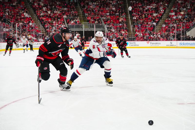 Nov 3, 2024; Raleigh, North Carolina, USA;  Washington Capitals left wing Alex Ovechkin (8) and Carolina Hurricanes defenseman Jaccob Slavin (74) chase after the puck during the second period at Lenovo Center. Mandatory Credit: James Guillory-Imagn Images