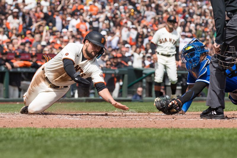 Apr 8, 2023; San Francisco, California, USA;  San Francisco Giants third baseman J.D. Davis (7) reaches for home to score in front of Kansas City Royals catcher Salvador Perez (13) during the fourth inning at Oracle Park. Mandatory Credit: John Hefti-USA TODAY Sports