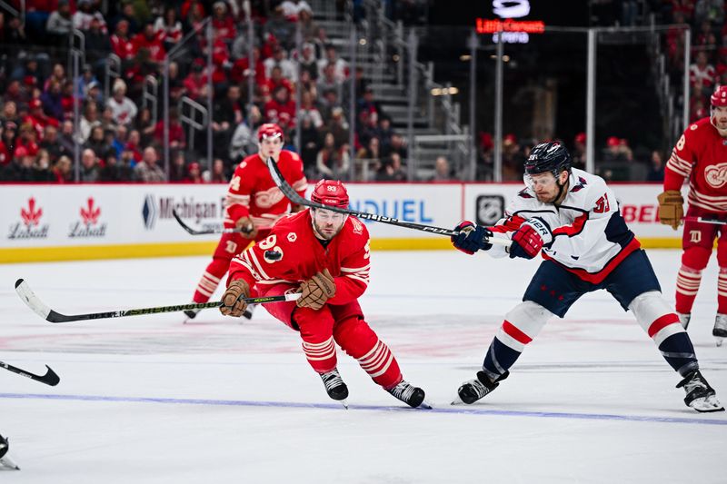 Dec 21, 2025; Detroit, Michigan, USA; Washington Capitals center Ethen Frank (53) and Detroit Red Wings right wing Alex Debrincat (93) battle for the puck during the second period at Little Caesars Arena. Mandatory Credit: Tim Fuller-Imagn Images