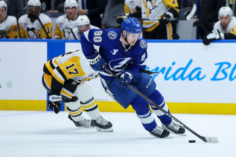 Dec 4, 2025; Tampa, Florida, USA; Tampa Bay Lightning defenseman J.J. Moser (90) controls the puck against the Pittsburgh Penguins in the second period at Benchmark International Arena. Mandatory Credit: Nathan Ray Seebeck-Imagn Images