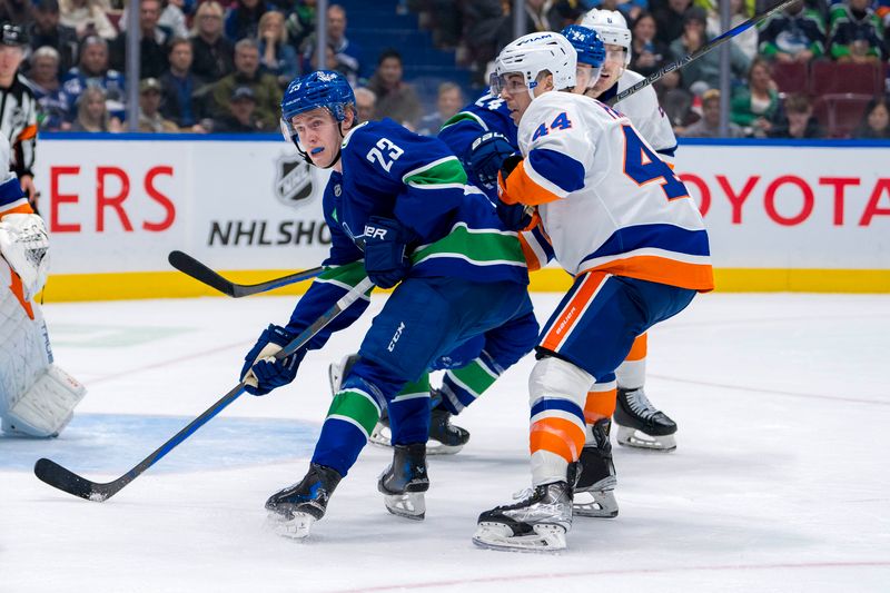 Nov 14, 2024; Vancouver, British Columbia, CAN; Vancouver Canucks forward Jonathan Lekkerimaki (23) battles with New York Islanders forward Jean-Gabriel Pageau (44) during the third period at Rogers Arena. Mandatory Credit: Bob Frid-Imagn Images