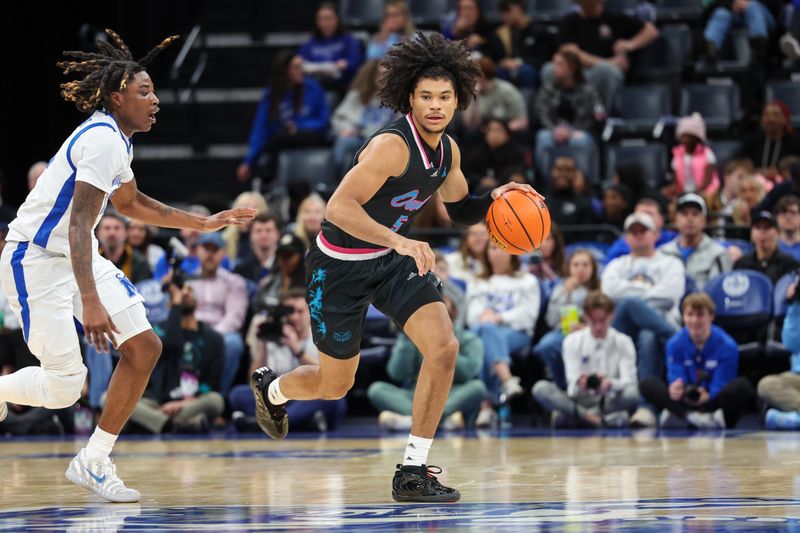 Jan 29, 2026; Memphis, Tennessee, USA; Florida Atlantic Owls guard Yohann Sissoko (5) dribbles the ball against Memphis Tigers guard Julius Thedford (15) during the second half at FedExForum. Mandatory Credit: Wesley Hale-Imagn Images