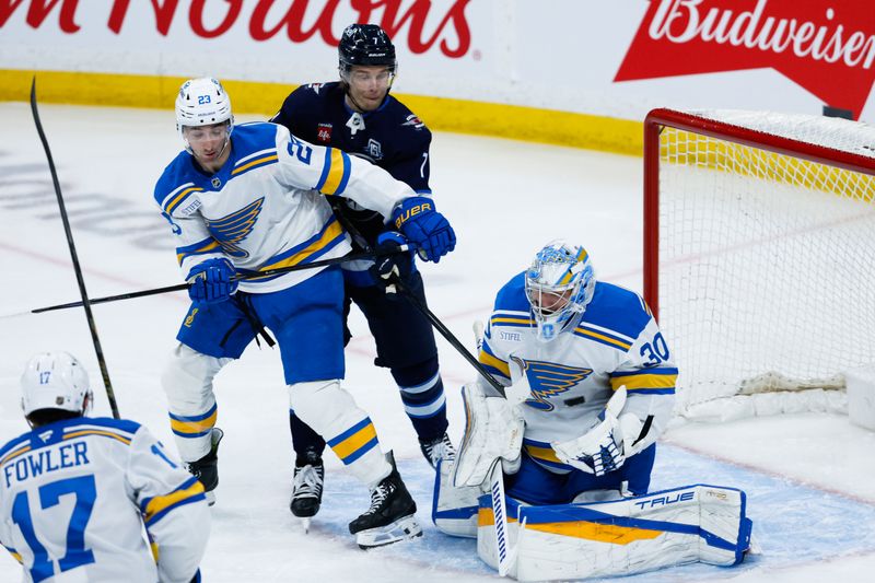 Jan 20, 2026; Winnipeg, Manitoba, CAN; Winnipeg Jets forward Vladislav Namestnikov (7) tries to deflect the puck past St. Louis Blues goalie Joel Hofer (30) during the second period at Canada Life Centre. Mandatory Credit: Terrence Lee-Imagn Images