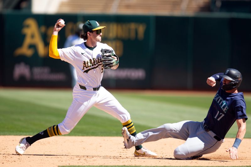 Sep 5, 2024; Oakland, California, USA; Oakland Athletics shortstop Jacob Wilson (5) throws over Seattle Mariners right fielder Mitch Haniger (17) too late to complete a double play during the sixth inning at Oakland-Alameda County Coliseum. Leo Rivas was safe at first base. Mandatory Credit: D. Ross Cameron-Imagn Images