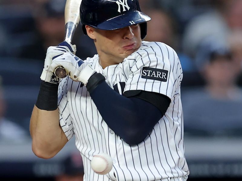 Jun 6, 2025; Bronx, New York, USA; New York Yankees shortstop Anthony Volpe (11) is hit by a pitch with the bases loaded for an RBI during the second inning against the Boston Red Sox at Yankee Stadium. Mandatory Credit: Brad Penner-Imagn Images