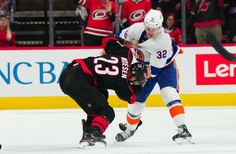 Apr 22, 2024; Raleigh, North Carolina, USA; Carolina Hurricanes right wing Stefan Noesen (23) and New York Islanders center Kyle MacLean (32) fight during the first period in game two of the first round of the 2024 Stanley Cup Playoffs at PNC Arena. Mandatory Credit: James Guillory-USA TODAY Sports