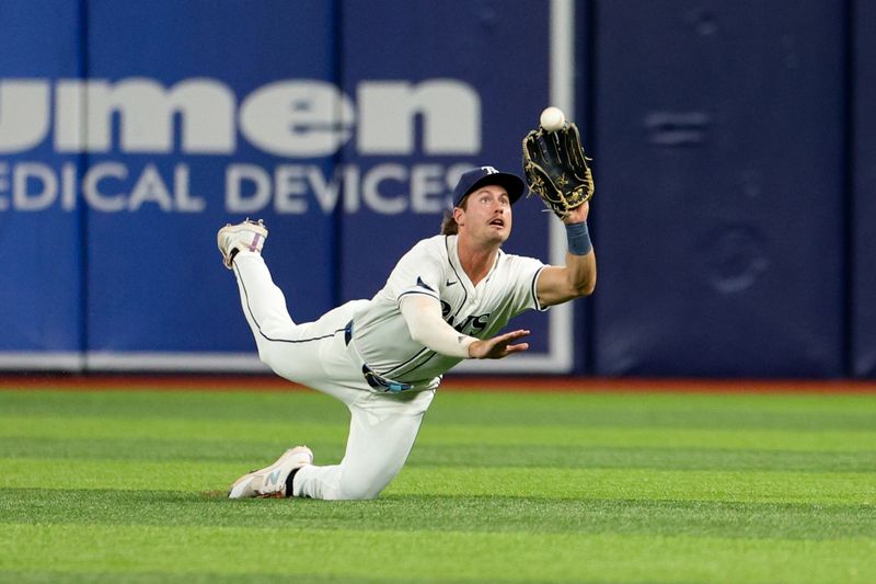 Jul 11, 2024; St. Petersburg, Florida, USA; Tampa Bay Rays outfielder Jonny DeLuca (21) makes a diving catch against the New York Yankees in the sixth inning at Tropicana Field. Mandatory Credit: Nathan Ray Seebeck-USA TODAY Sports