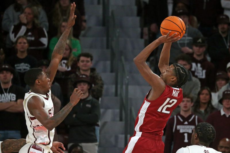 Feb 17, 2024; Starkville, Mississippi, USA; Arkansas Razorbacks guard Tramon Mark (12) shoots the ball against Mississippi State Bulldogs guard Shawn Jones Jr. (5) during the first half at Humphrey Coliseum. Mandatory Credit: Petre Thomas-USA TODAY Sports