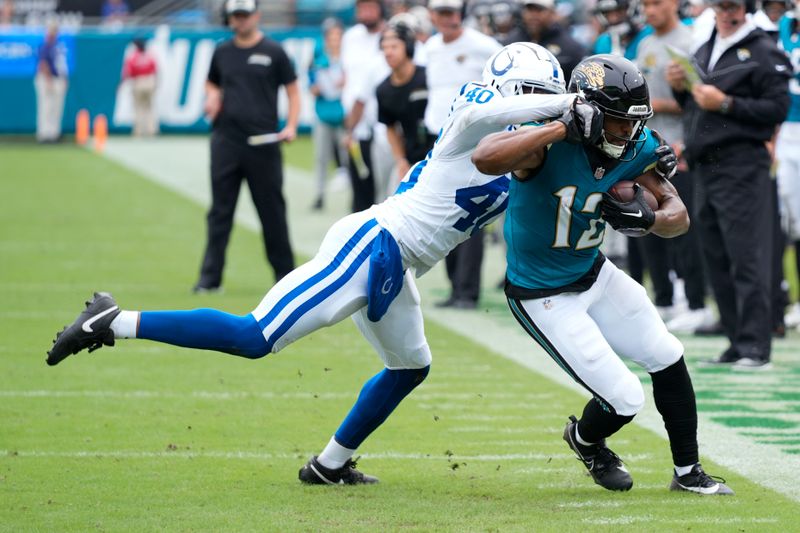 Jacksonville Jaguars wide receiver Devin Duvernay (12) is tackled by Indianapolis Colts' Jaylon Jones (40) during the first half of an NFL football game, Sunday, Oct. 6, 2024, in Jacksonville, Fla. (AP Photo/John Raoux)