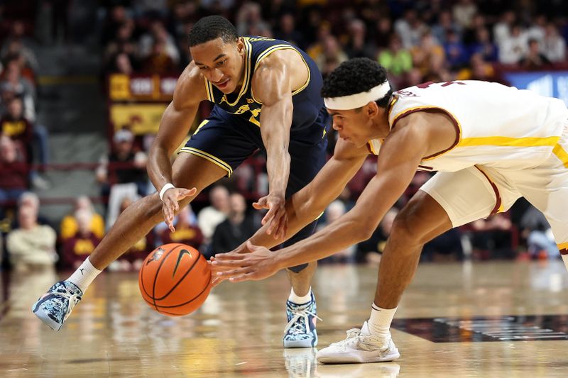 Jan 16, 2025; Minneapolis, Minnesota, USA; Michigan Wolverines guard Nimari Burnett (4) and Minnesota Golden Gophers guard Isaac Asuma (1) dive for the ball during the second half at Williams Arena. Mandatory Credit: Matt Krohn-Imagn Images