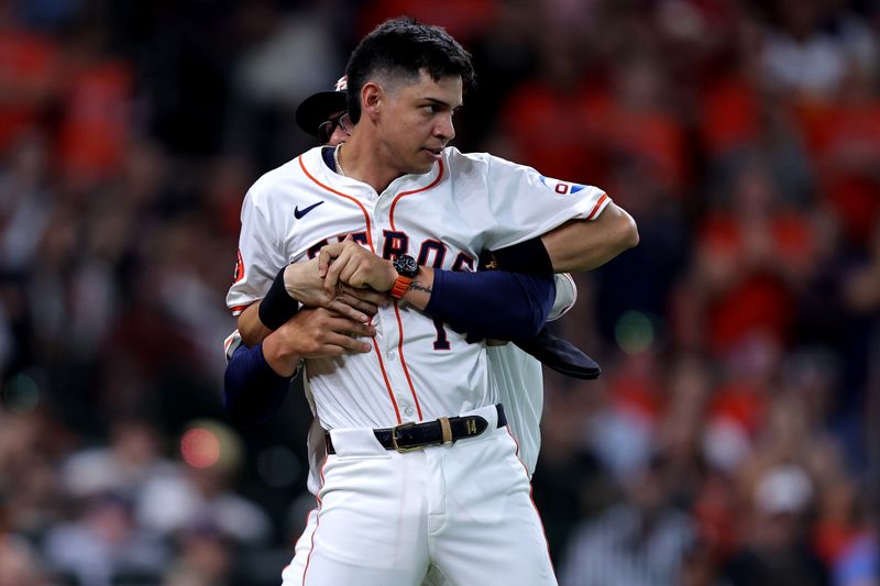 Jul 13, 2024; Houston, Texas, USA; Houston Astros right fielder Mauricio Dubon (14) is restrained by Houston Astros bench coach Omar Lopez (22) after being ejected against the Texas Rangers during the ninth inning at Minute Maid Park. Mandatory Credit: Erik Williams-USA TODAY Sports