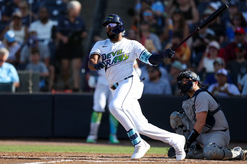 Apr 19, 2025; Tampa, Florida, USA; Tampa Bay Rays third baseman Junior Caminero (13) doubles against the New York Yankees in the fourth inning at George M. Steinbrenner Field. Mandatory Credit: Nathan Ray Seebeck-Imagn Images