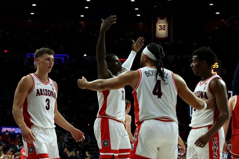 Jan 6, 2024; Tucson, Arizona, USA; Arizona Wildcats center Oumar Ballo (11) celebrates with the fans next to guard Pelle Larsson (3), guard Kylan Boswell (4), and guard Jaden Bradley (0) on the sidelines during a timeout against the Utah Utes during the first half at McKale Center. Mandatory Credit: Zachary BonDurant-USA TODAY Sports