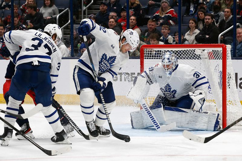 Dec 23, 2023; Columbus, Ohio, USA; Toronto Maple Leafs defenseman Jake McCabe (22) clears the rebound of a Toronto Maple Leafs goalie Martin Jones (31) save against the Columbus Blue Jackets during the third period at Nationwide Arena. Mandatory Credit: Russell LaBounty-USA TODAY Sports