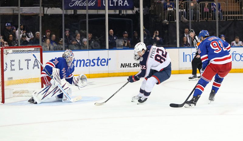 Jan 18, 2025; New York, New York, USA; Columbus Blue Jackets left wing Mikael Pyyhtia (82) attempts a shot at New York Rangers goalie Igor Shesterkin (31) while New York Rangers right wing Reilly Smith (91) defends during the second period at Madison Square Garden. Mandatory Credit: Danny Wild-Imagn Images