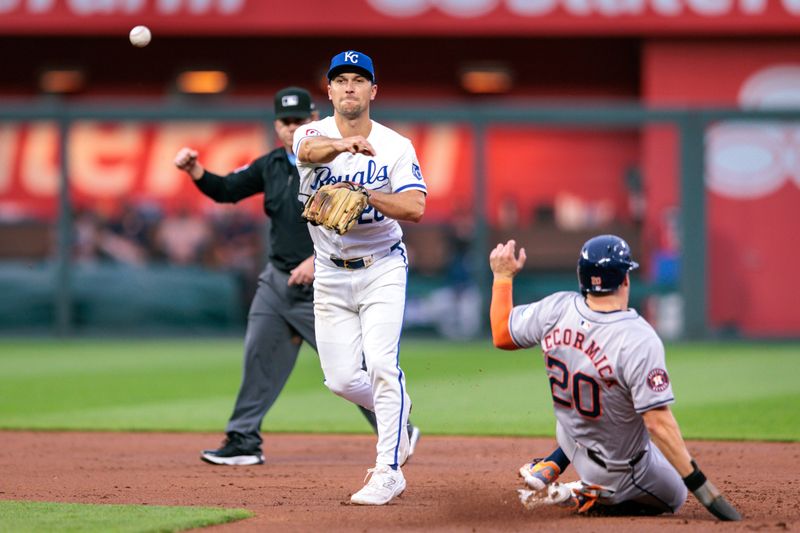 Apr 10, 2024; Kansas City, Missouri, USA; Kansas City Royals outfielder Kyle Isbel (28) throws to first base as Houston Astros outfielder Chas McCormick (20) slides into 2nd base during the second inning at Kauffman Stadium. Mandatory Credit: William Purnell-USA TODAY Sports