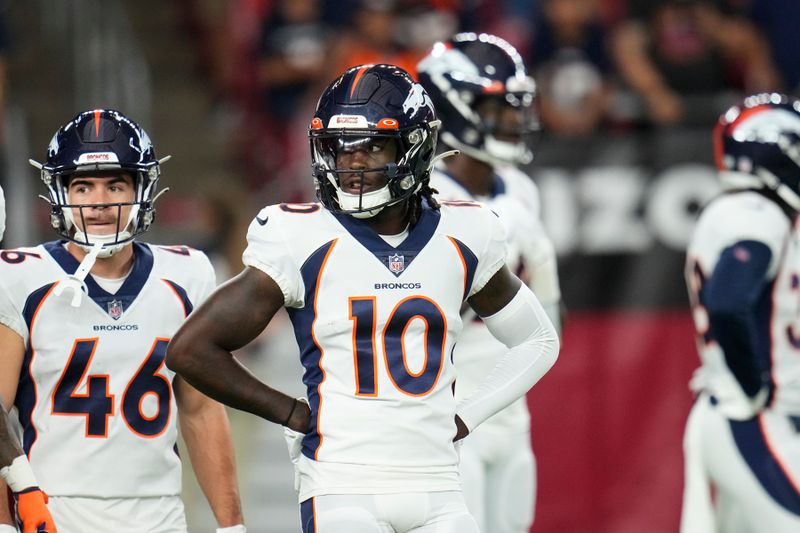 Denver Broncos wide receivers Jerry Jeudy (10) and Michael Bandy (46) pause on the field prior to an NFL preseason football game against the Arizona Cardinals, Friday, Aug. 11, 2023, in Glendale, Ariz. (AP Photo/Ross D. Franklin)