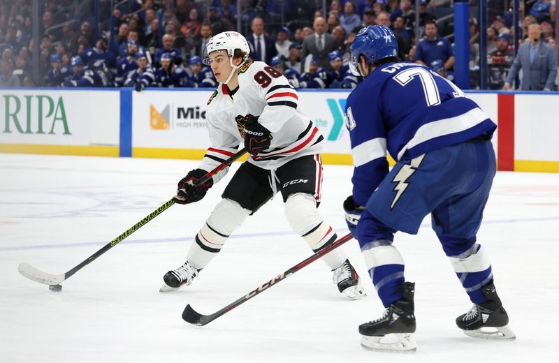 Jan 28, 2025; Tampa, Florida, USA; Chicago Blackhawks center Connor Bedard (98) skates with the puck as Tampa Bay Lightning center Anthony Cirelli (71) defends during the second period at Amalie Arena. Mandatory Credit: Kim Klement Neitzel-Imagn Images