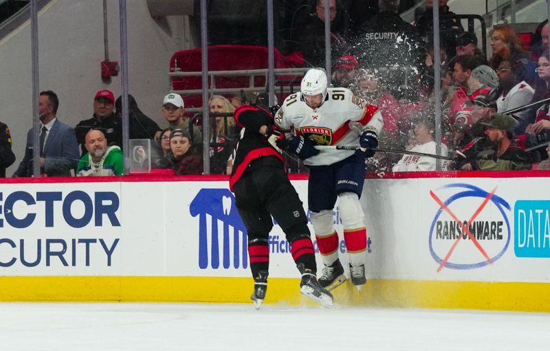 Mar 14, 2024; Raleigh, North Carolina, USA; Florida Panthers defenseman Oliver Ekman-Larsson (91) checks Carolina Hurricanes right wing Andrei Svechnikov (37) during the first period at PNC Arena. Mandatory Credit: James Guillory-USA TODAY Sports