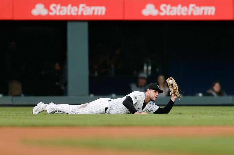May 10, 2024; Denver, Colorado, USA; Colorado Rockies right fielder Sean Bouchard (12) gestures after making a catch for an out in the fifth inning against the Texas Rangers at Coors Field. Mandatory Credit: Isaiah J. Downing-USA TODAY Sports