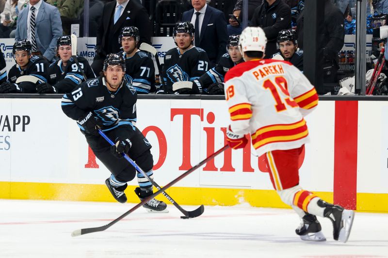 Oct 15, 2025; Salt Lake City, Utah, USA; Utah Mammoth left wing Brandon Tanev (13) skates against Calgary Flames defenseman Zayne Parekh (19) during the first period at Delta Center. Mandatory Credit: Rob Gray-Imagn Images