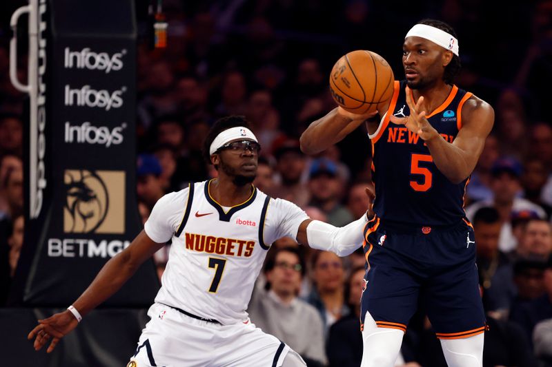 NEW YORK, NEW YORK - JANUARY 25: Precious Achiuwa #5 of the New York Knicks passes the ball as Reggie Jackson #7 of the Denver Nuggets defends during the first half at Madison Square Garden on January 25, 2024 in New York City. NOTE TO USER: User expressly acknowledges and agrees that, by downloading and/or using this Photograph, user is consenting to the terms and conditions of the Getty Images License Agreement. (Photo by Sarah Stier/Getty Images)