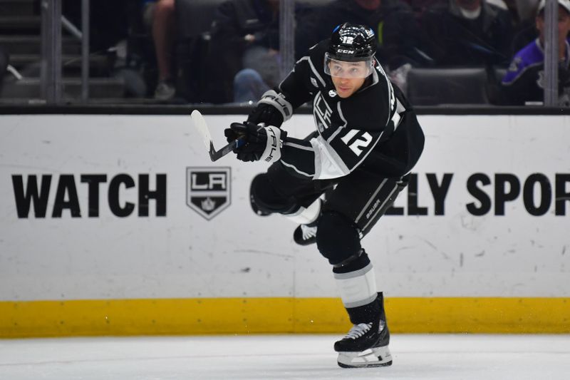 Mar 11, 2024; Los Angeles, California, USA; Los Angeles Kings left wing Trevor Moore (12) shoots on goal against the New York Islanders during the second period at Crypto.com Arena. Mandatory Credit: Gary A. Vasquez-USA TODAY Sports