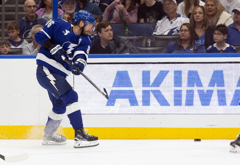 Oct 15, 2024; Tampa, Florida, USA; Tampa Bay Lightning right wing Nikita Kucherov (86) passes the puck against the Vancouver Canucks during the first period at Amalie Arena. Mandatory Credit: Kim Klement Neitzel-Imagn Images