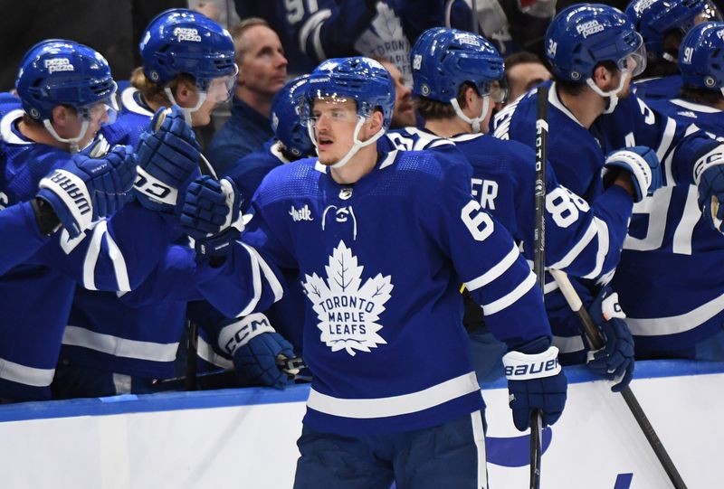 Apr 11, 2024; Toronto, Ontario, CAN; Toronto Maple Leafs forward David Kampf (64) celebrates with team mates at the bench after scoring a goal against the New Jersey Devils in the second period at Scotiabank Arena. Mandatory Credit: Dan Hamilton-USA TODAY Sports