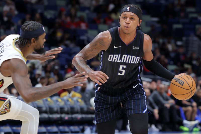 NEW ORLEANS, LOUISIANA - OCTOBER 10: Paolo Banchero #5 of the Orlando Magic dribbles the ball as Naji Marshall #8 of the New Orleans Pelicans defends the play during the second half of a preseason game at the Smoothie King Center on October 10, 2023 in New Orleans, Louisiana. NOTE TO USER: User expressly acknowledges and agrees that, by downloading and or using this Photograph, user is consenting to the terms and conditions of the Getty Images License Agreement. (Photo by Jonathan Bachman/Getty Images)