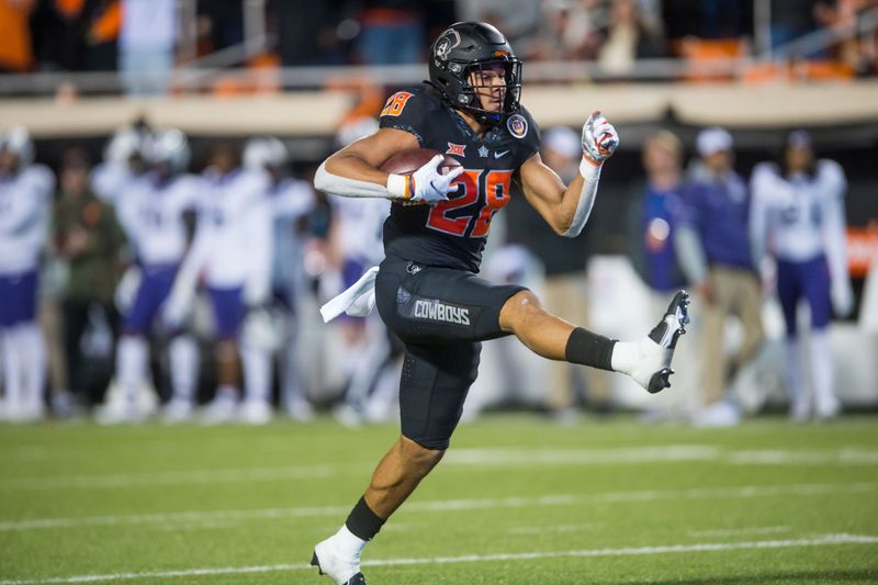 Nov 13, 2021; Stillwater, Oklahoma, USA;  Oklahoma State Cowboys wide receiver Blaine Green (28) high steps into the end zone for a touchdown during the second quarter against the TCU Horned Frogsat Boone Pickens Stadium. Mandatory Credit: Brett Rojo-USA TODAY Sports