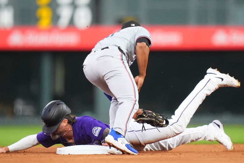 Aug 26, 2024; Denver, Colorado, USA; Miami Marlins second base Otto Lopez (61) tags out Colorado Rockies outfielder Jake Cave (11) on a steal in the fourth inning at Coors Field. Mandatory Credit: Ron Chenoy-USA TODAY Sports