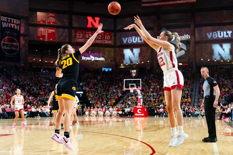 Feb 11, 2024; Lincoln, Nebraska, USA; Nebraska Cornhuskers forward Natalie Potts (22) shoots a three point shot against Iowa Hawkeyes guard Kate Martin (20) during the first quarter at Pinnacle Bank Arena. Mandatory Credit: Dylan Widger-USA TODAY Sports