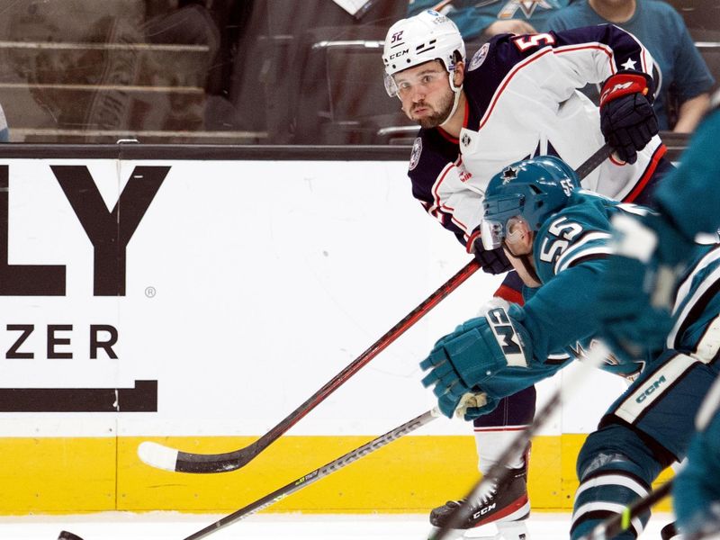 Mar 14, 2023; San Jose, California, USA; Columbus Blue Jackets right winger Emil Bemstrom (52) passes the puck around San Jose Sharks defenseman Derrick Pouliot (55) during the third period at SAP Center at San Jose. Mandatory Credit: D. Ross Cameron-USA TODAY Sports