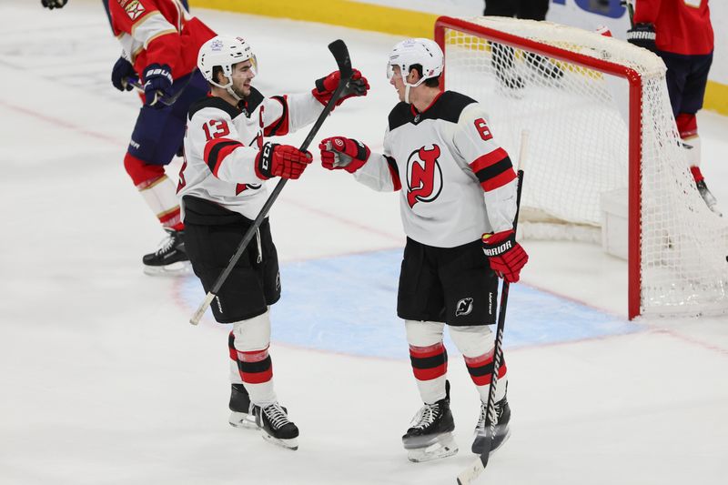 Jan 13, 2024; Sunrise, Florida, USA; New Jersey Devils defenseman John Marino (6) celebrates with center Nico Hischier (13) after scoring against the Florida Panthers during the third period at Amerant Bank Arena. Mandatory Credit: Sam Navarro-USA TODAY Sports