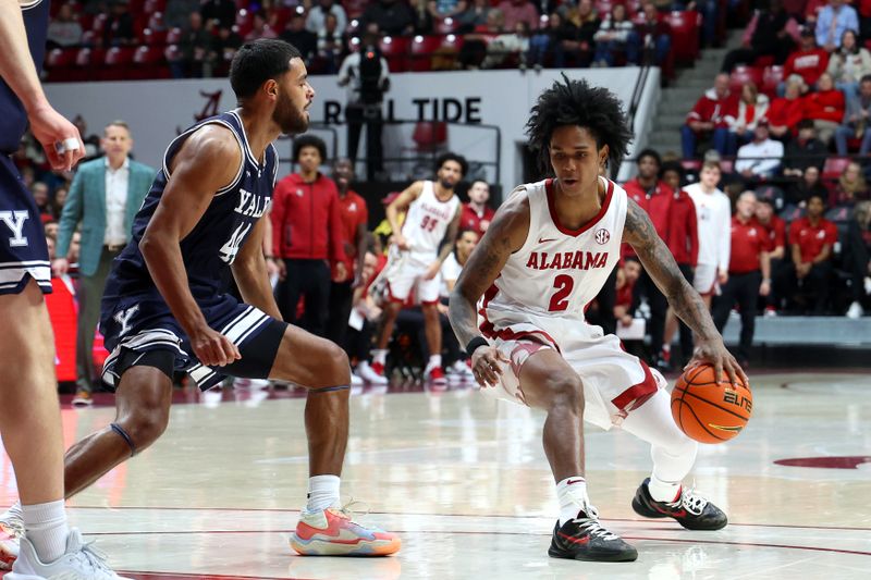 Dec 29, 2025; Tuscaloosa, Alabama, USA; Alabama Crimson Tide guard Aden Holloway (2) dribbles against Yale Bulldogs guard Devon Arlington (44) during the first half at Coleman Coliseum. Mandatory Credit: David Leong-Imagn Images